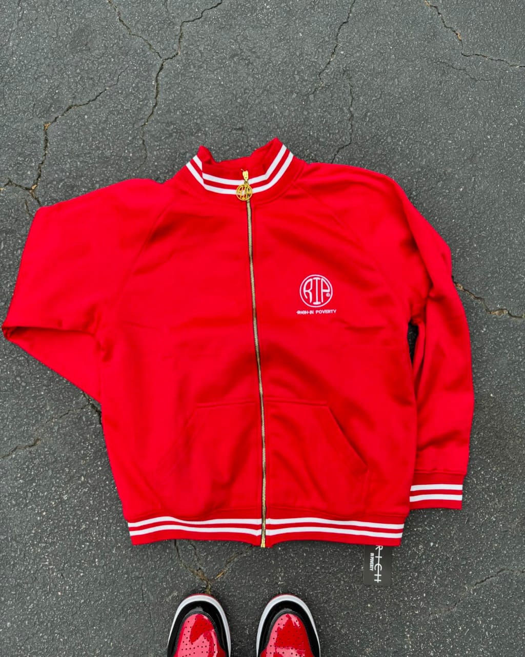 Red polyester tracksuit featuring a matching jacket and pants designed for comfort and everyday wear.